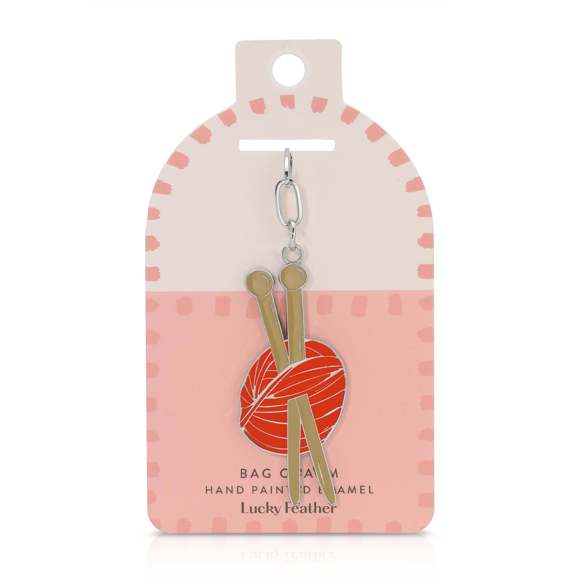 Keychain with knitting needles and yarn ball design on a pink and white packaging