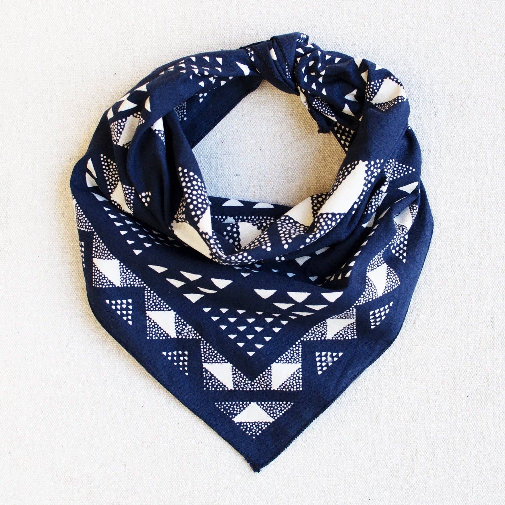 Navy blue bandana with white geometric pattern on a light gray background