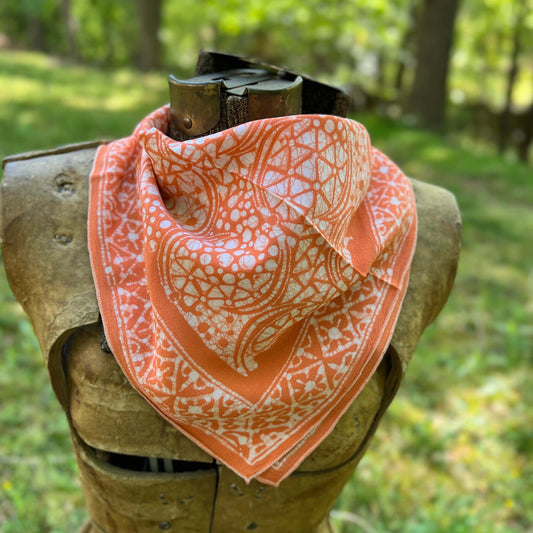 Orange and white patterned bandana  with a natural background