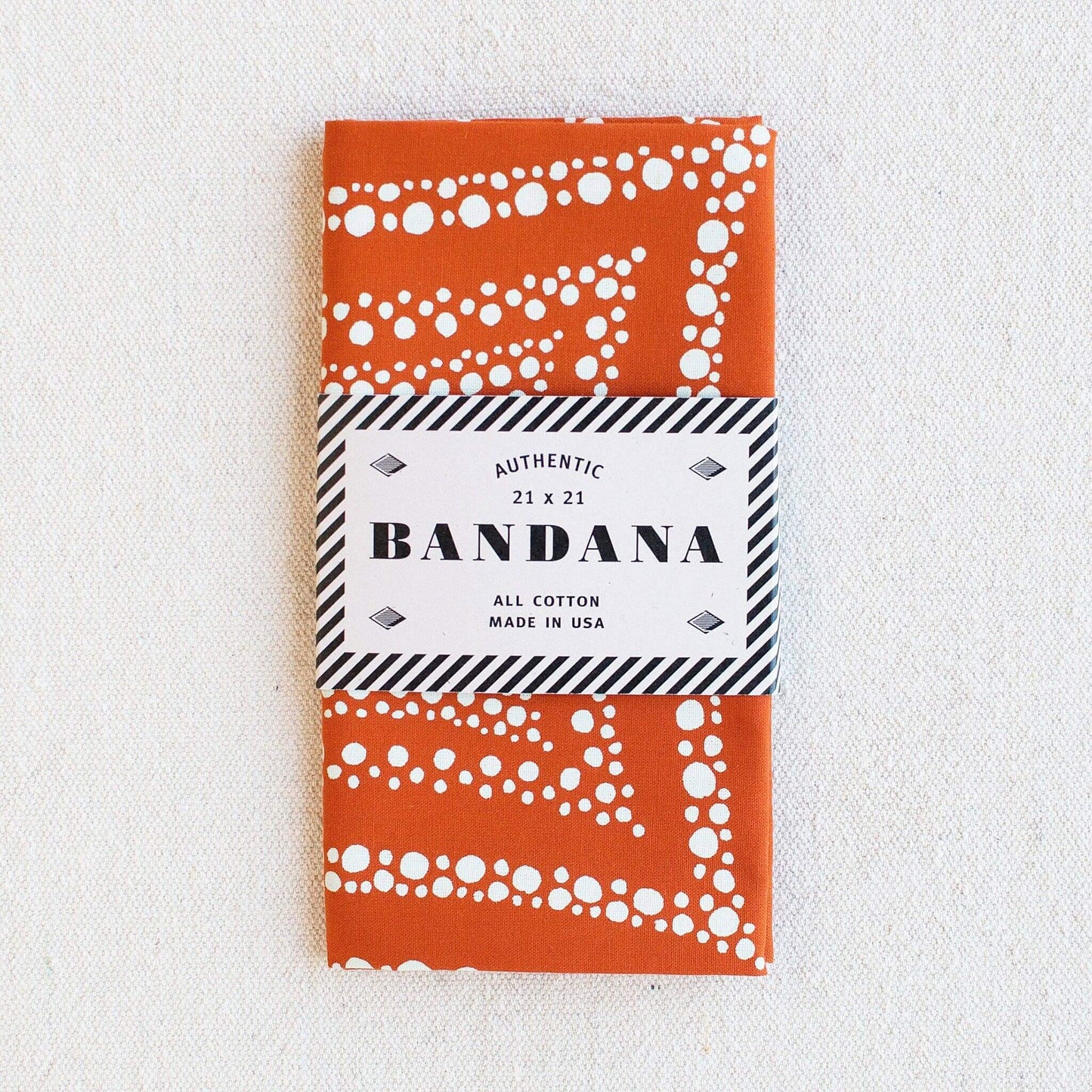Orange bandana with white patterns on a white background