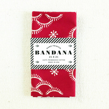 Red bandana with white patterns and packaging on a white background