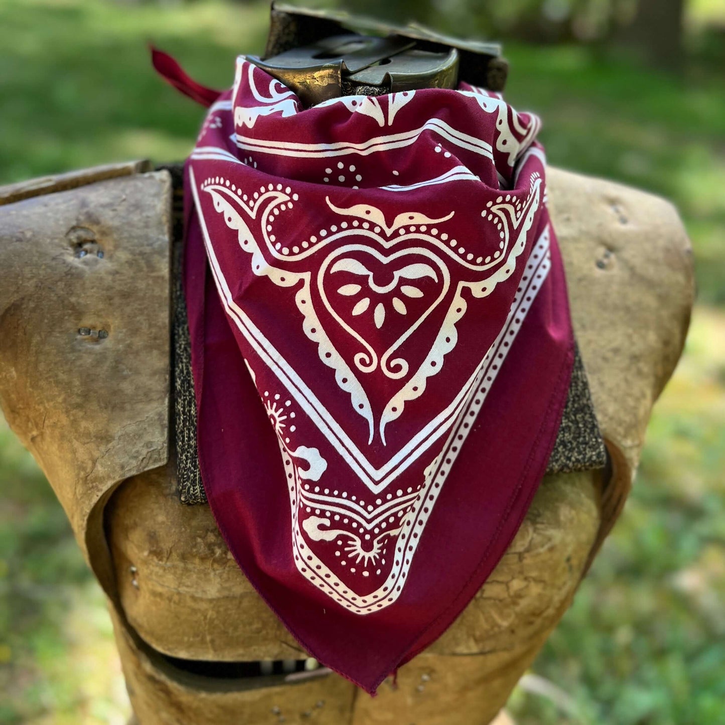 Red bandana with white patterns draped over a wooden object outdoors