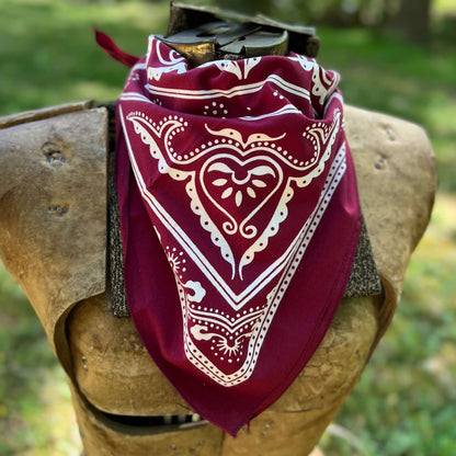 Red bandana with white patterns draped over a wooden object outdoors