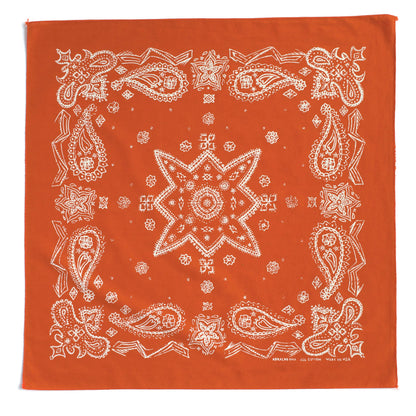 An orange bandana featuring a white paisley and starburst pattern, photographed flat against a white background.