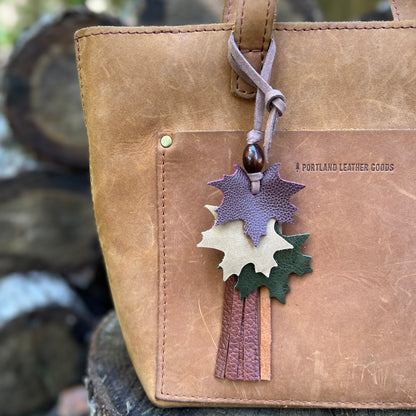 autumn leaves in wine, tan and green with brown leather tassel and wooden bead on brown purse