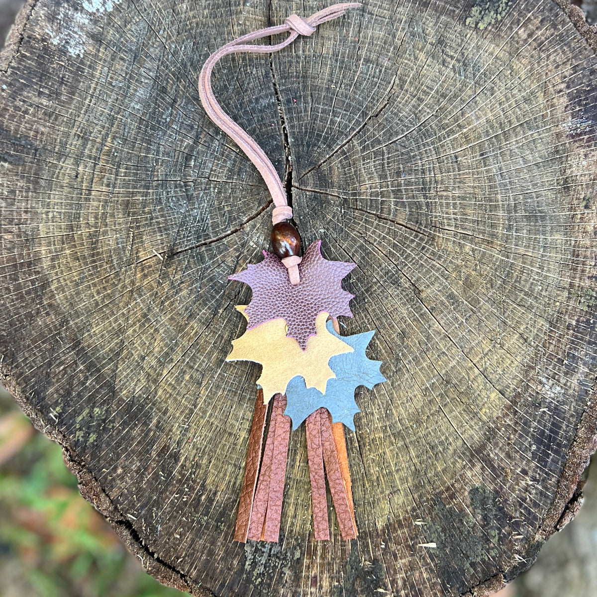 autumn leaves in wine, tan and green with brown leather tassel and wooden bead on brown purse