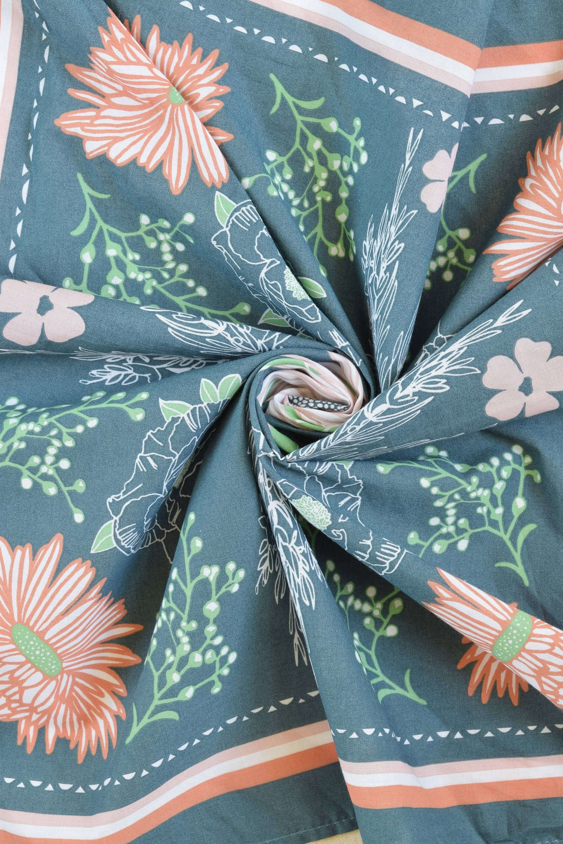 Close-up of fabric with floral pattern on a teal background