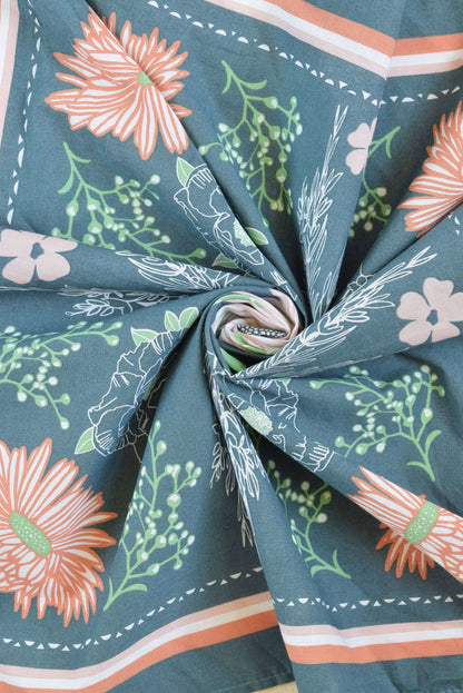 Close-up of fabric with floral pattern on a teal background