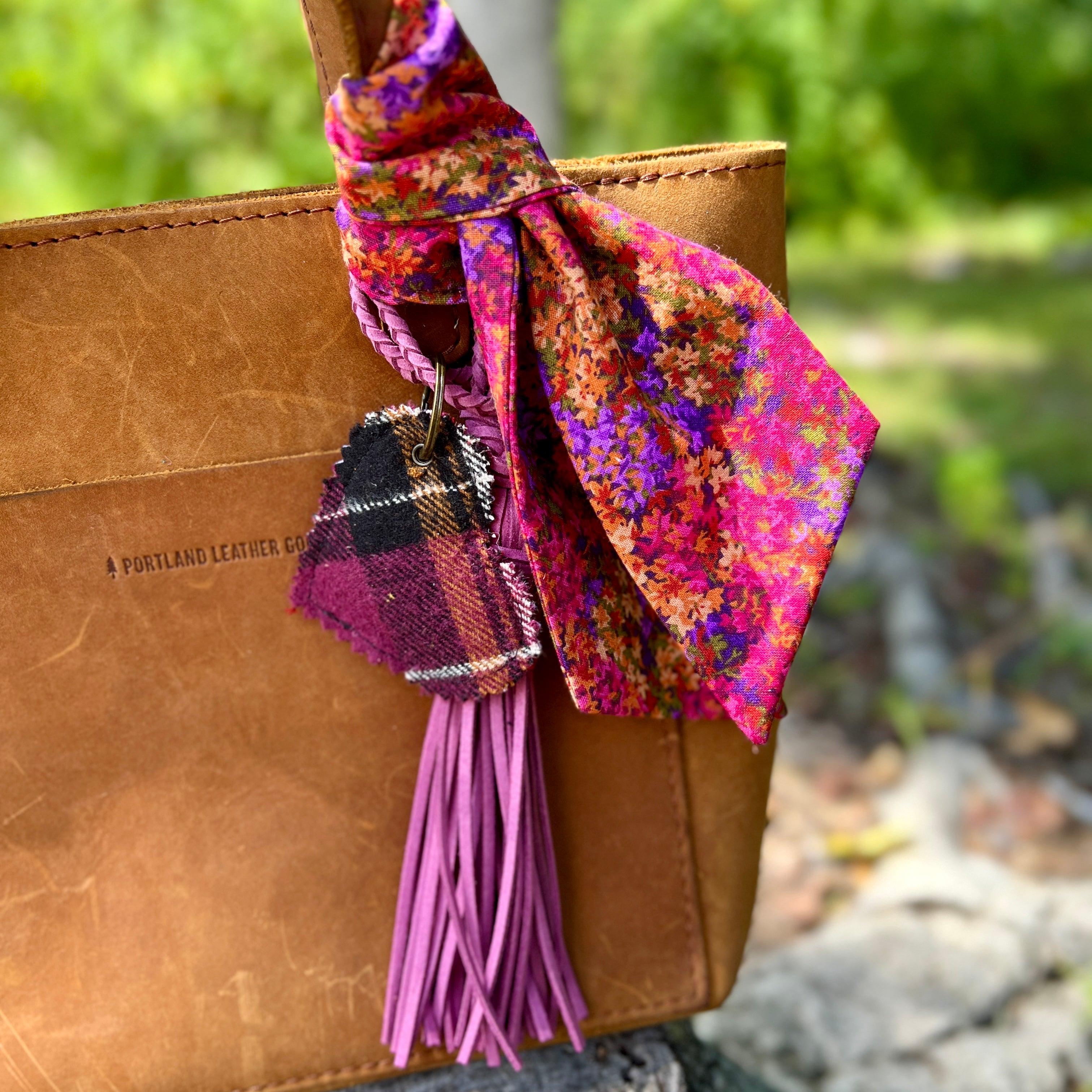 Brown leather bag with a colorful bow and tassel on a  natural background