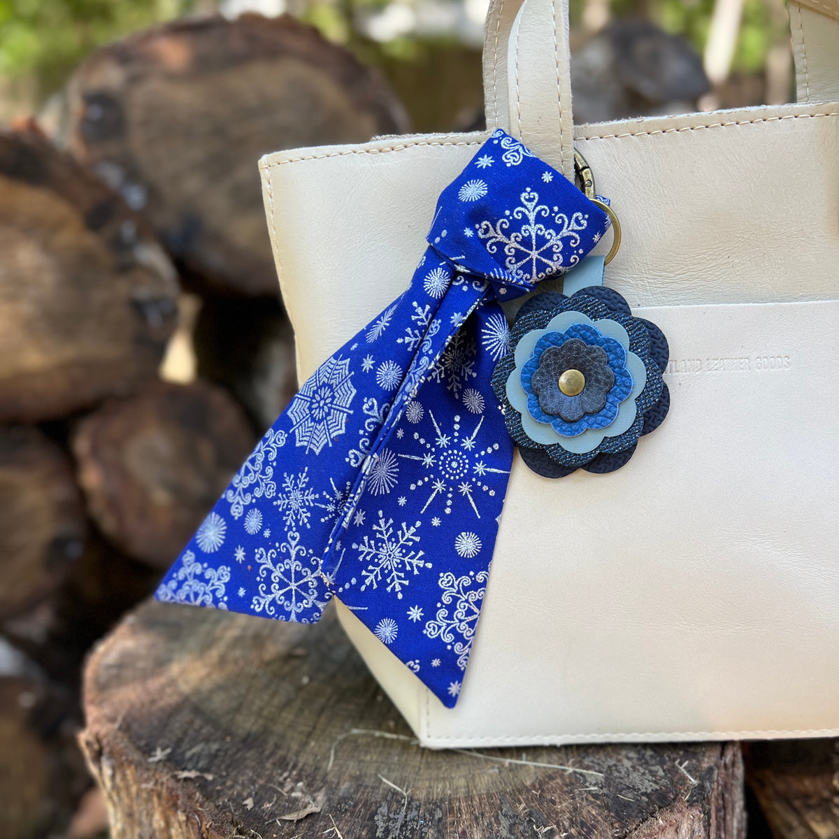 blue and silver snowflake print purse scarf with blue flower on off white bag