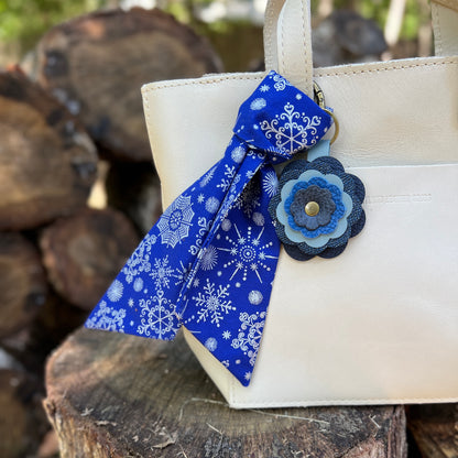 blue and silver snowflake print purse scarf with blue flower on off white bag