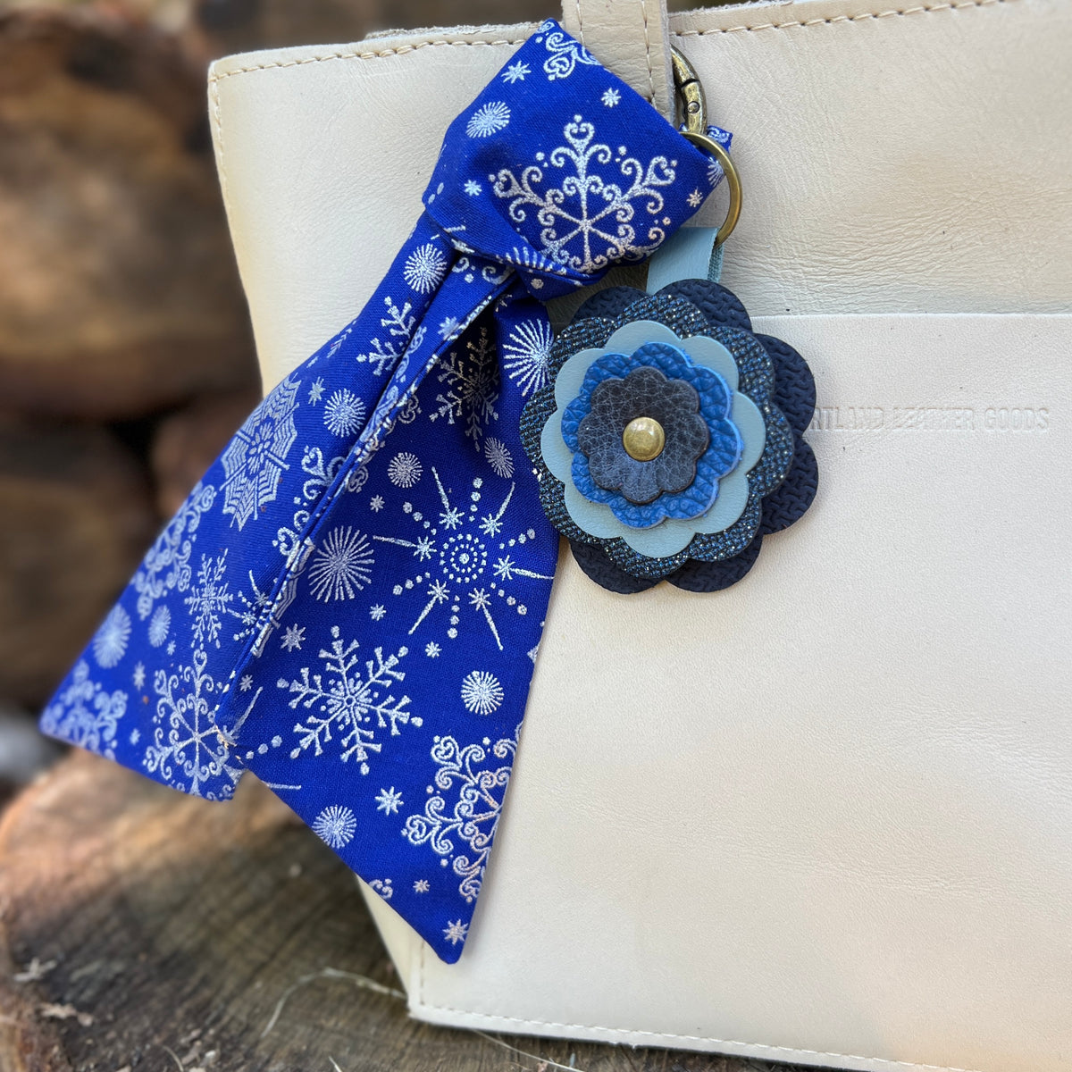 blue and silver snowflake print purse scarf with blue flower on off white bag