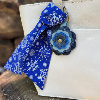 blue and silver snowflake print purse scarf with blue flower on off white bag