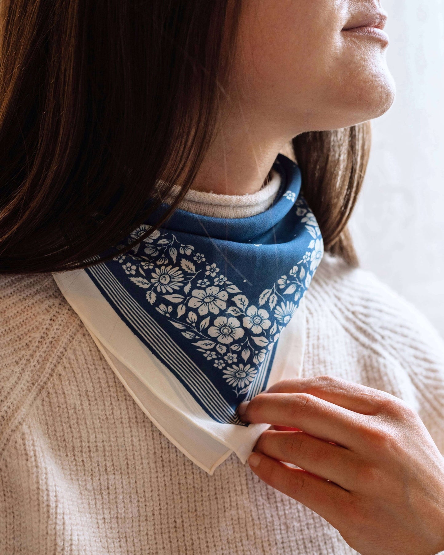 Person wearing a blue patterned scarf around their neck