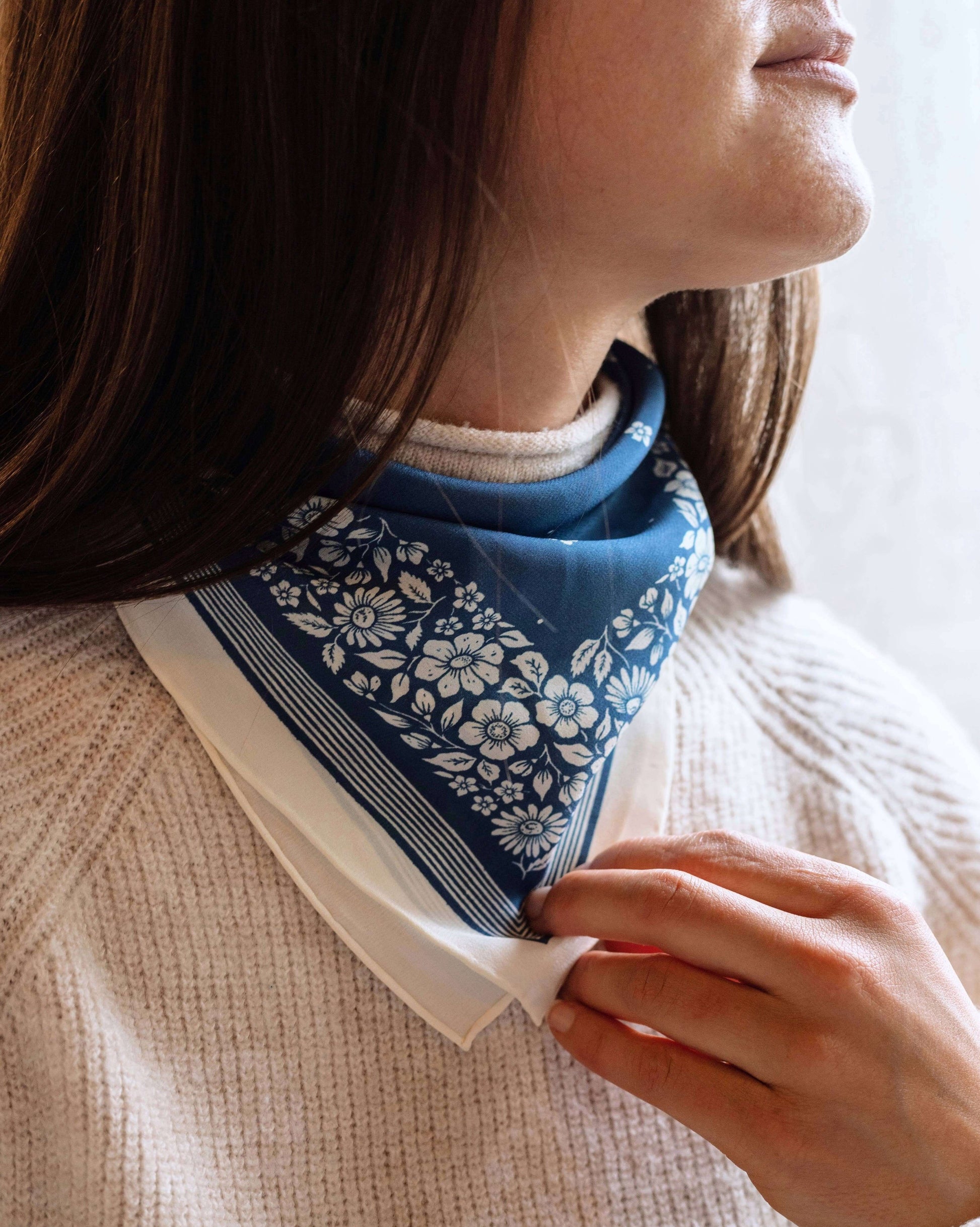 Person wearing a blue patterned scarf around their neck