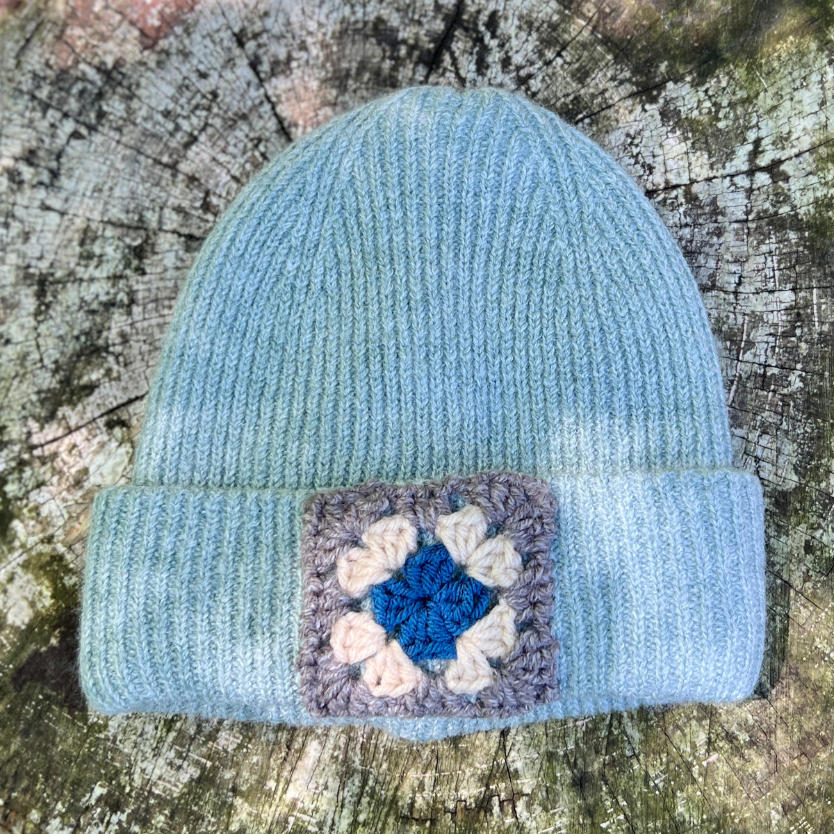 blue knit beanie with crochet patch in grey, white and blue