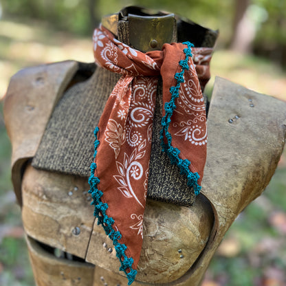 brown and white paisley bandana with blue cotton trim tied on dress form 