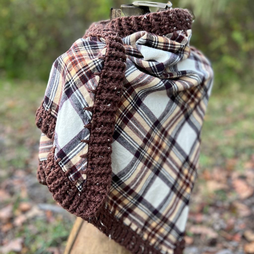 Plaid scarf with brown crochet edge on a mannequin against a natural background