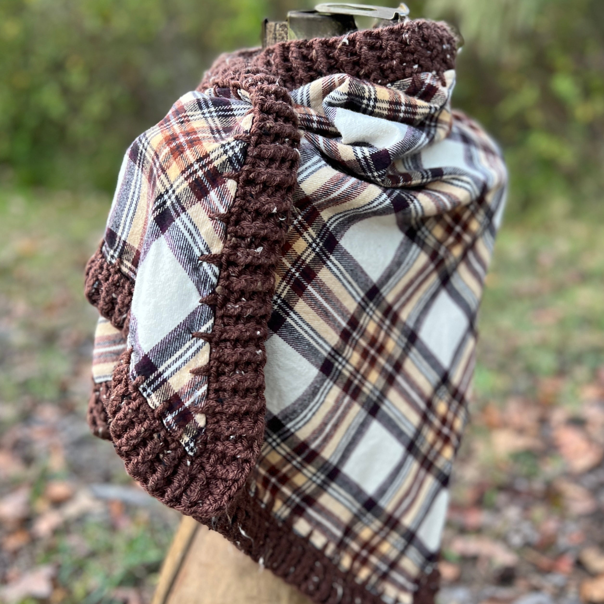 Plaid scarf with brown crochet edge on a mannequin against a natural background