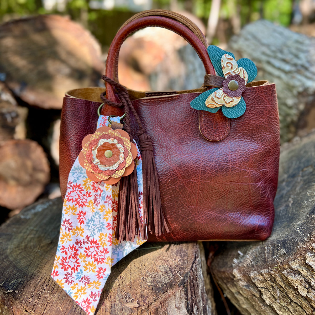 brown tote with colorful bag charms scarf and brown tassel