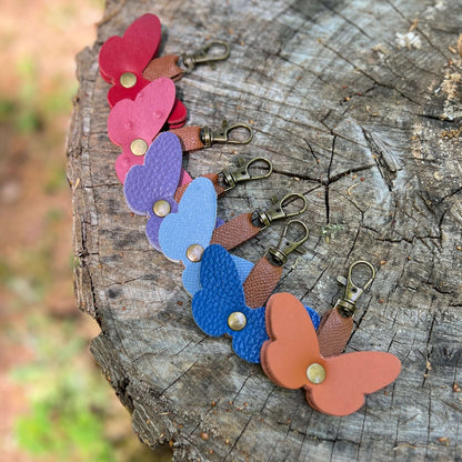 Colorful butterfly-shaped keychains on a wooden surface