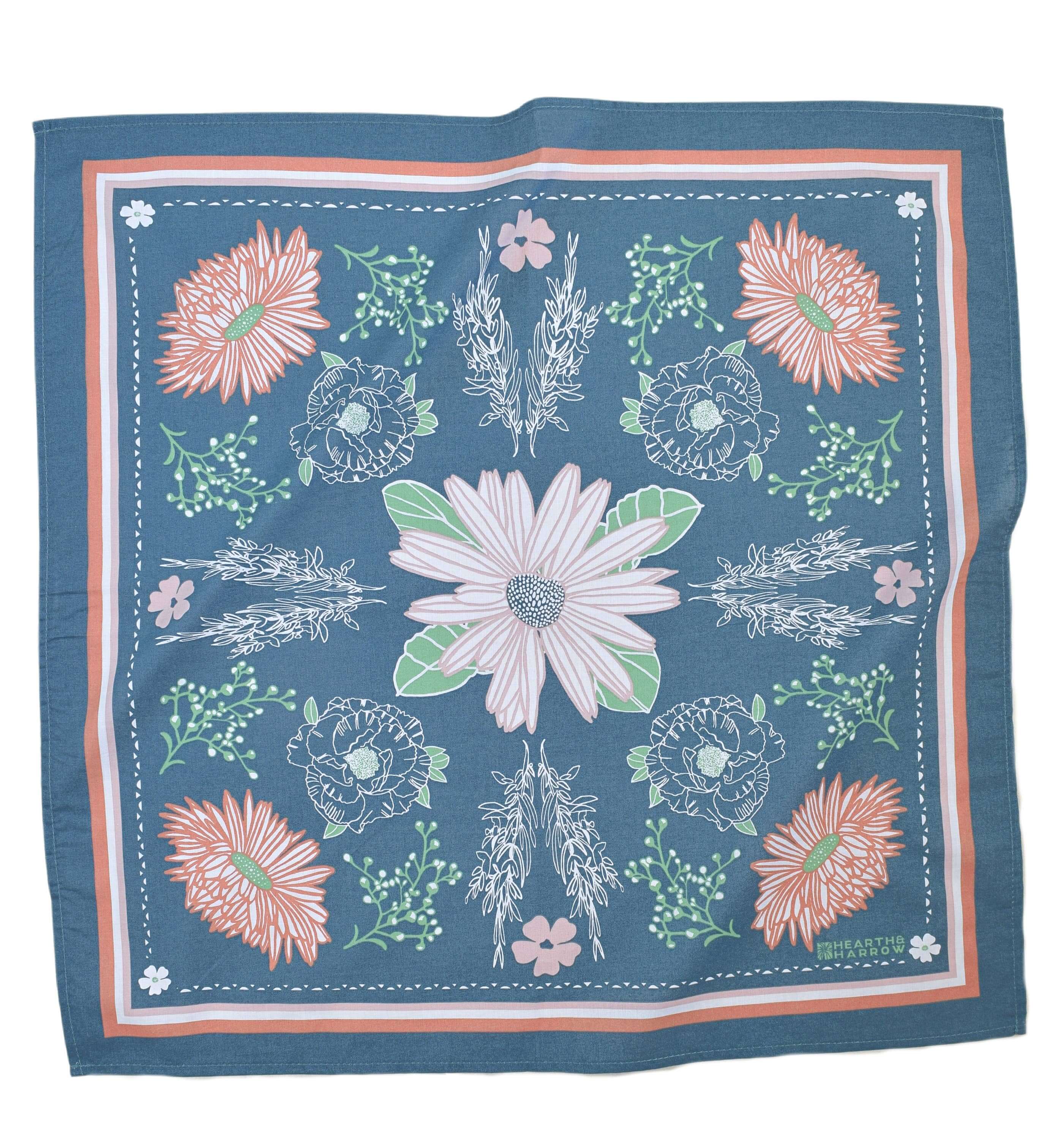 Floral patterned fabric square with pink, green, and white flowers on a blue background