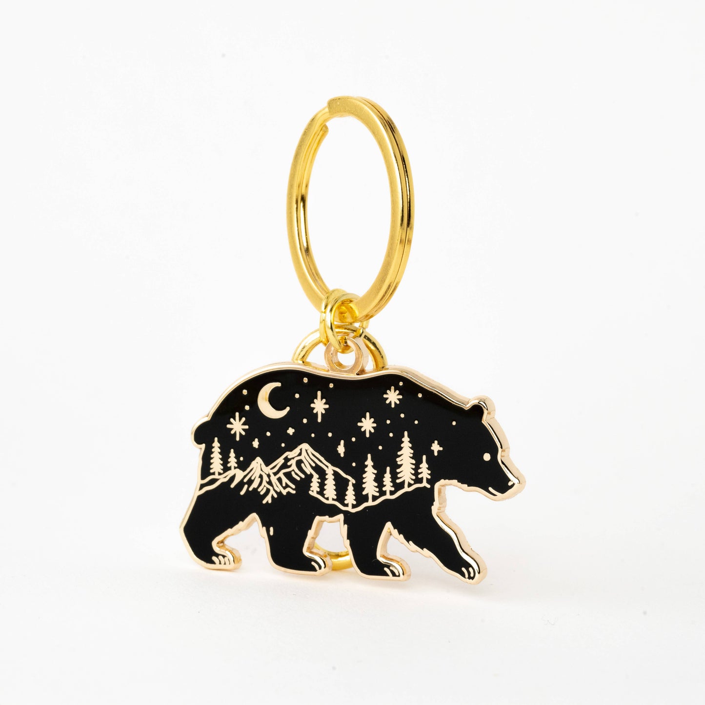 Gold keychain with a bear charm featuring mountain and star design on a white background