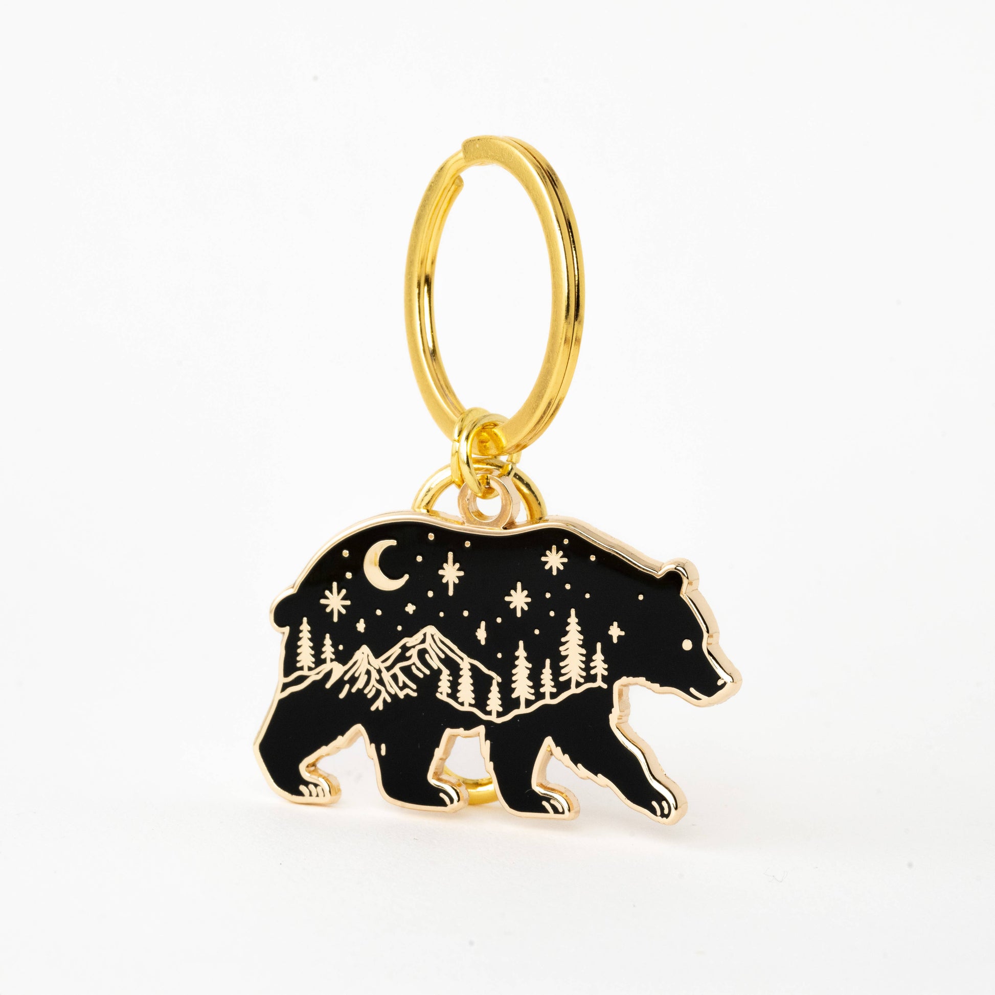 Gold keychain with a bear charm featuring mountain and star design on a white background