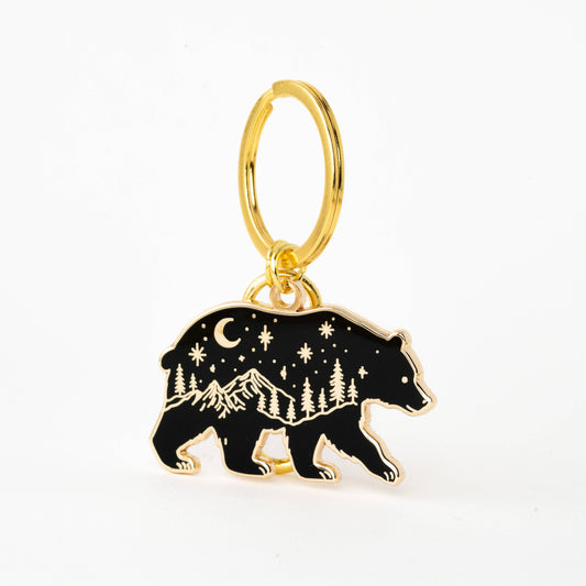 Gold keychain with a bear charm featuring mountain and star design on a white background