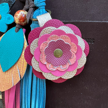 close up pink flower bag charm on wooden surface
