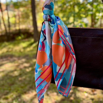 colorful abstract floral scarf on brown handbag