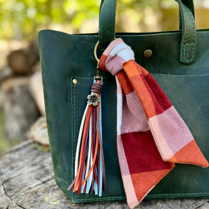 colorful faux suede tassel with flower charm with plaid scarf on green bag