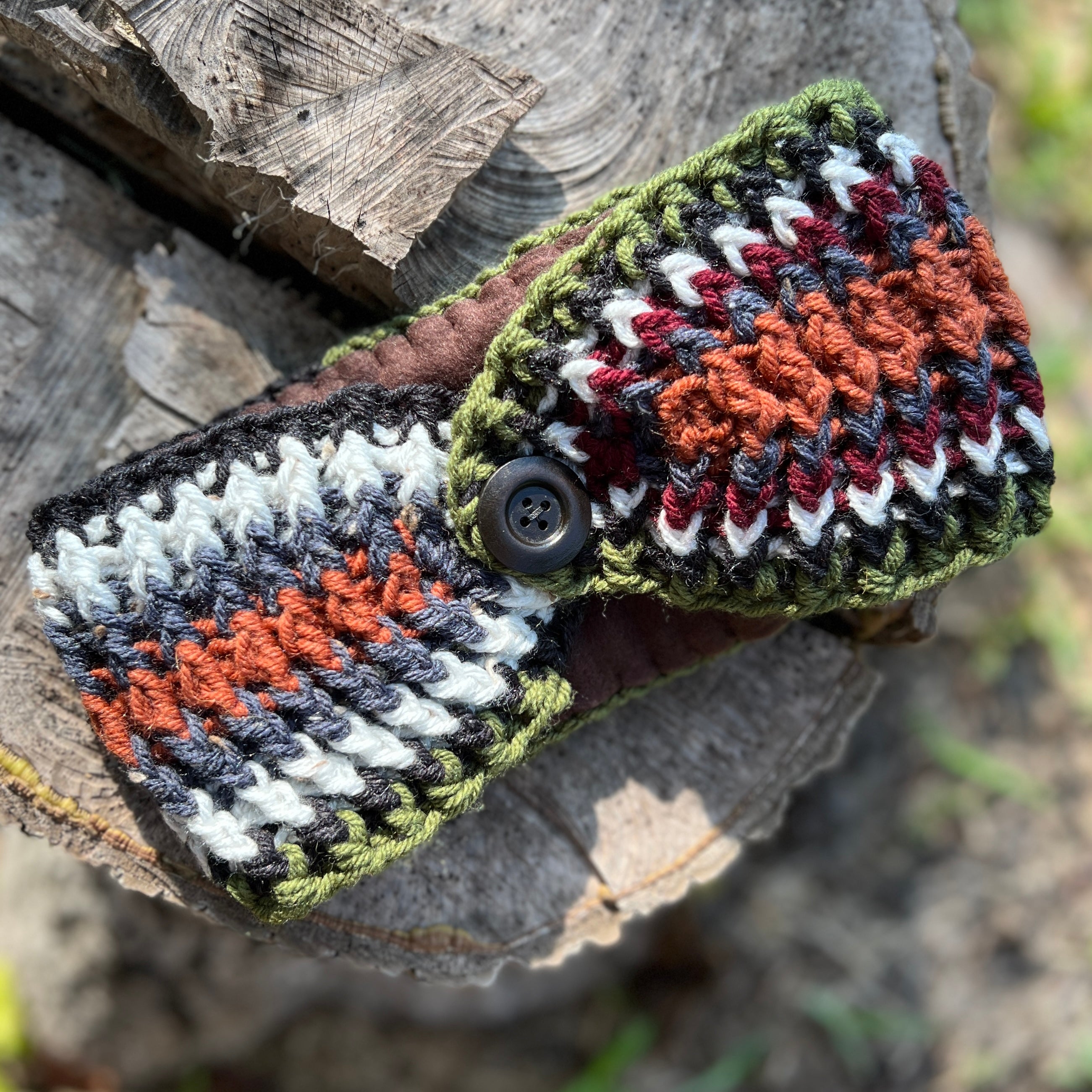 Crocheted headband with button closure on a wooden surface