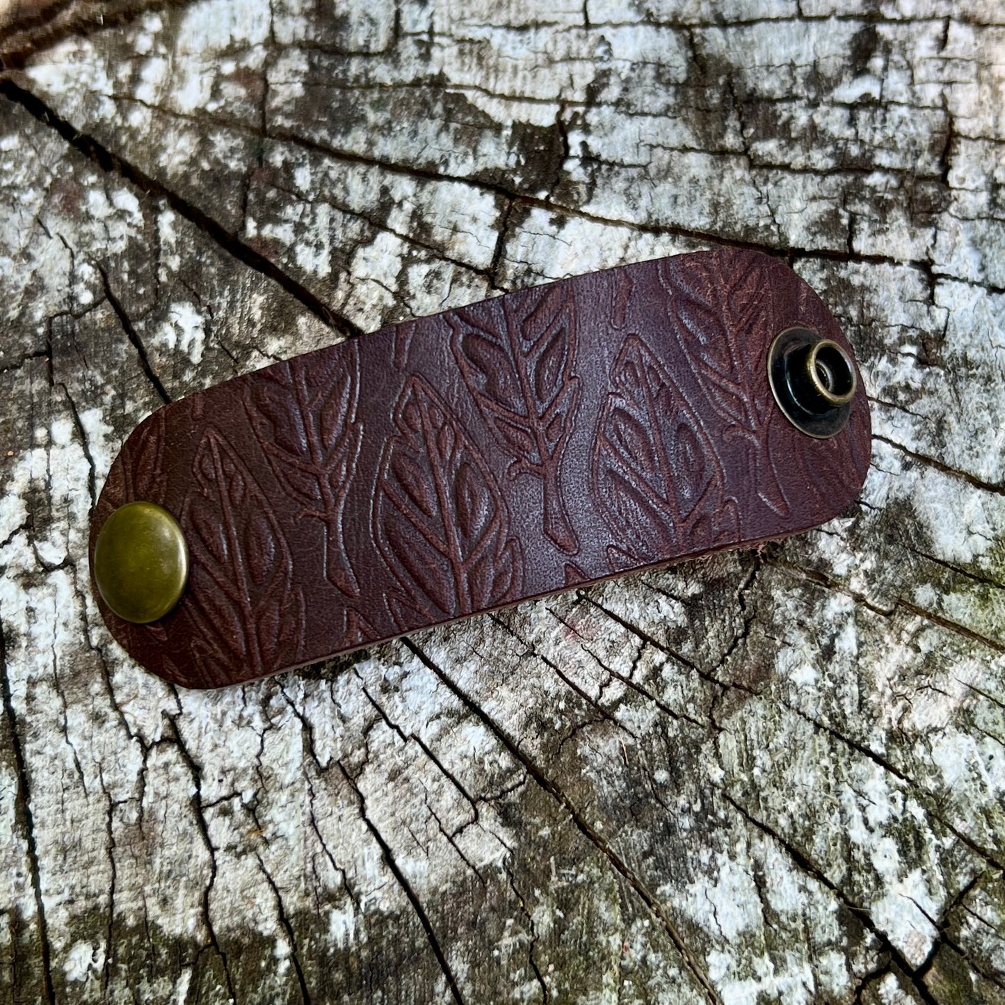 dark brown leather bandana slide embossed with feathers