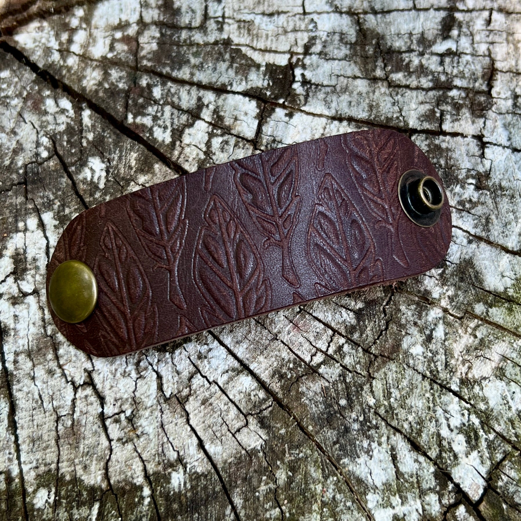 dark brown leather bandana slide embossed with feathers