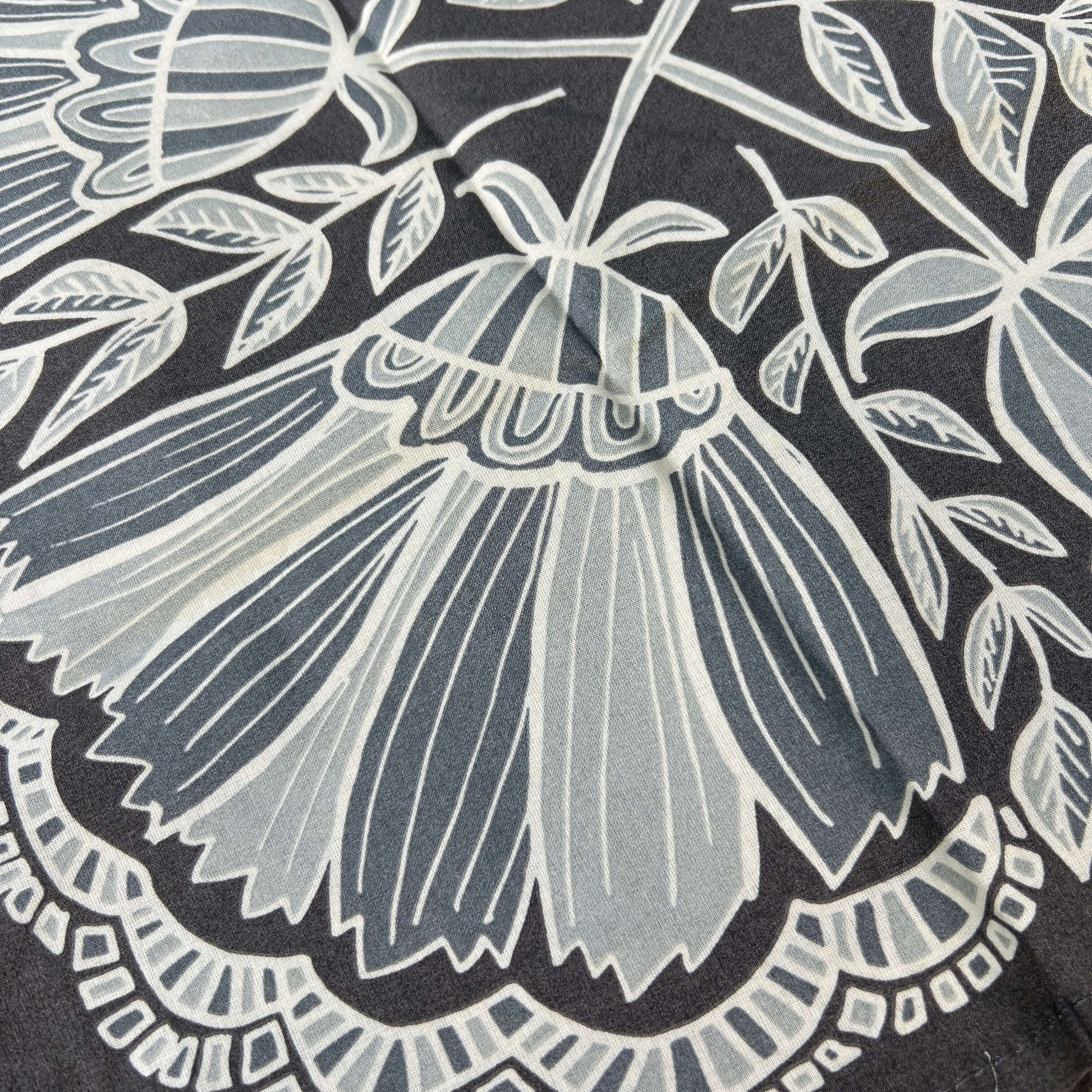 Close-up of a floral pattern with a prominent butterfly design on a dark background.