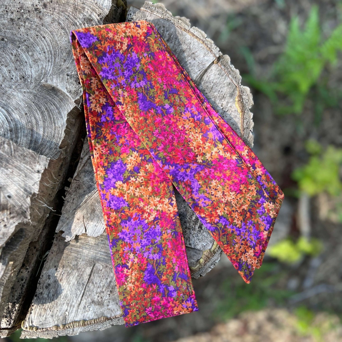 purse scarf on a wooden log 