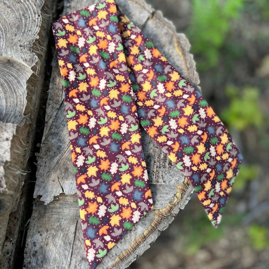 purse scarf with fall leaves on wooded background
