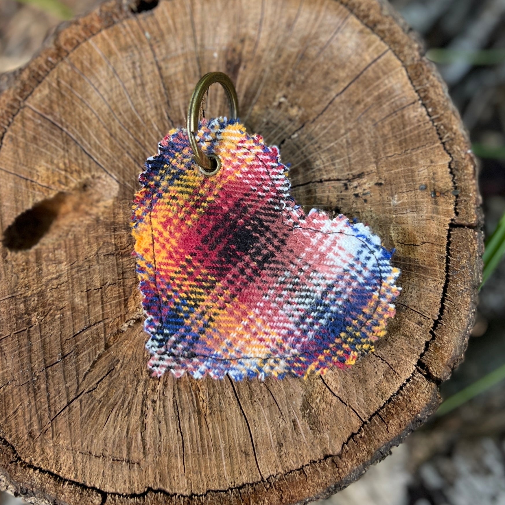 Colorful heart-shaped keychain on a wooden stump