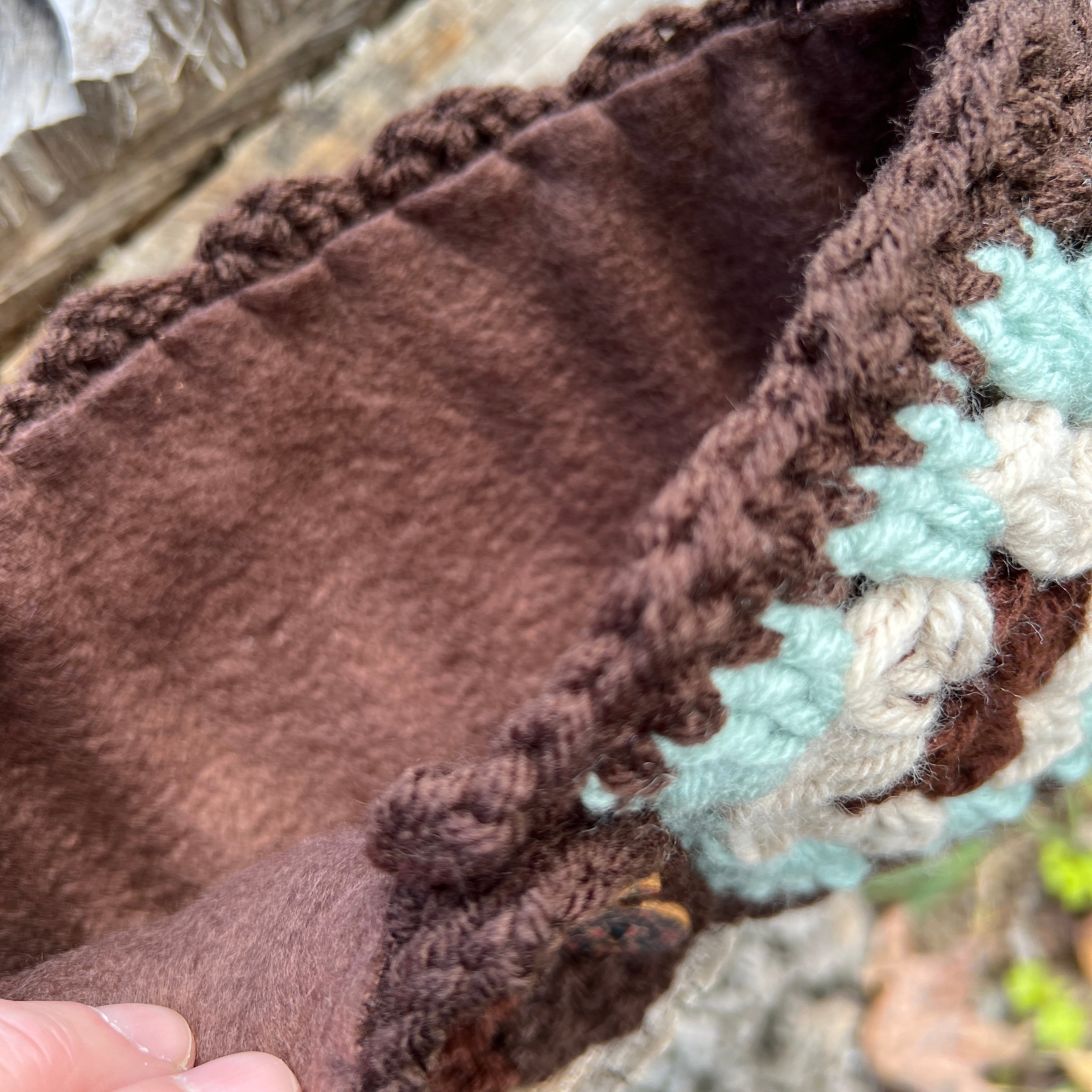 Close-up of a brown and light blue knitted fabric with a textured pattern.