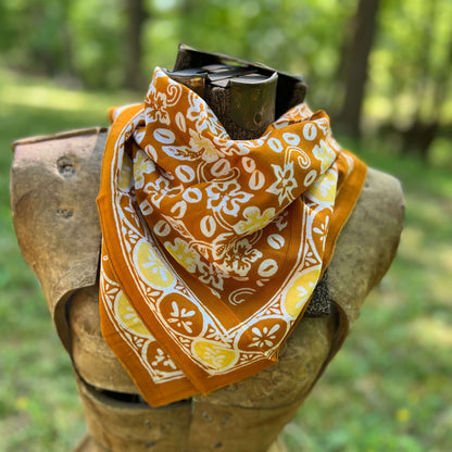 Orange bandana with white patterns against a blurred natural background