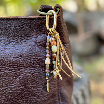gold glass beaded bag charm with tassel and feather charm
