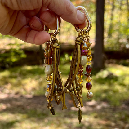 gold glass beaded bag charm with tassel and feather charm
