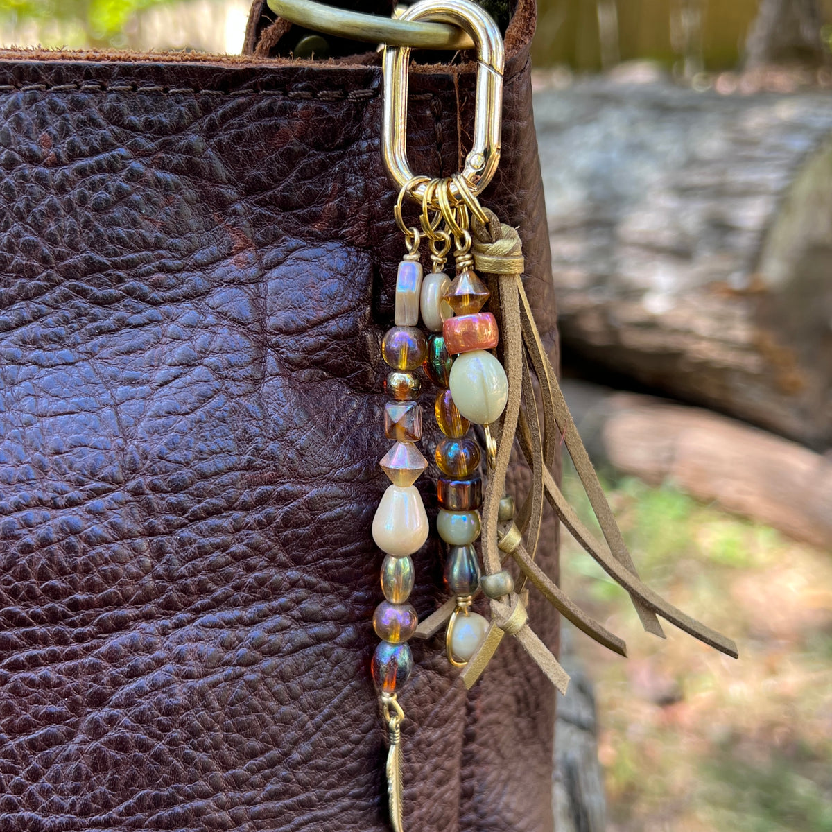 gold glass beaded bag charm with tassel and feather charm