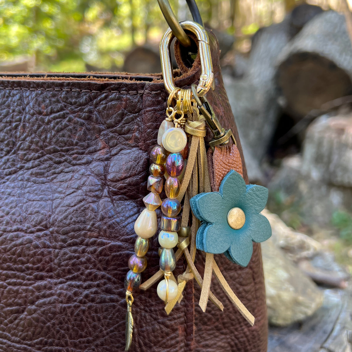 gold glass beaded bag charm with tassel and feather charm