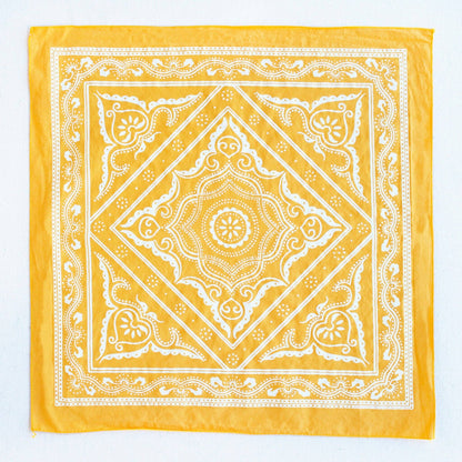 Yellow bandana with white intricate patterns on a white background
