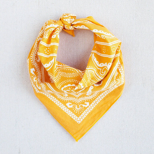 Yellow bandana with white patterns on a light gray background