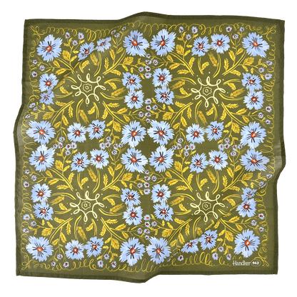 Floral patterned fabric with blue flowers and green leaves on a white background