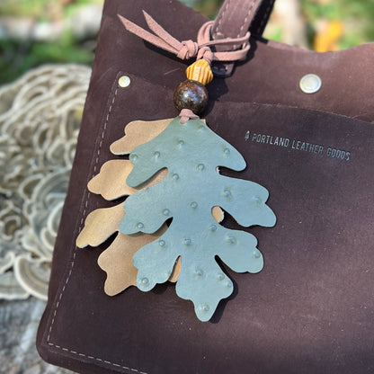 green and tan oak leaves with wooden beads leather bag charm on dark brown tote