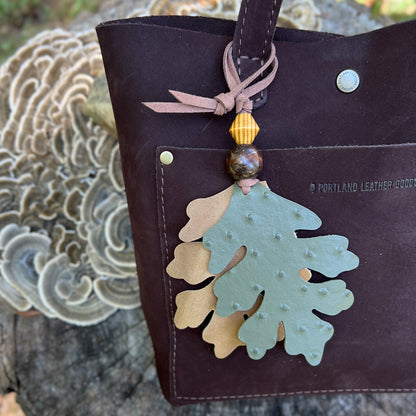 green and tan oak leaves with wooden beads leather bag charm on dark brown tote